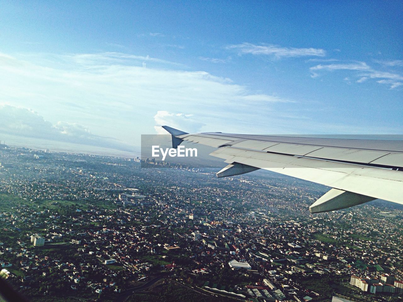 Cropped image of airplane flying over cityscape