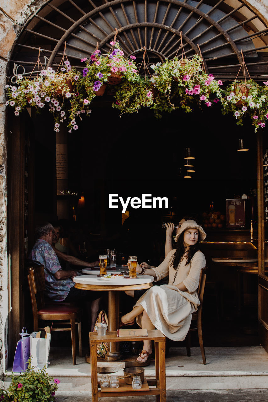 Woman looking away while sitting on chair at restaurant