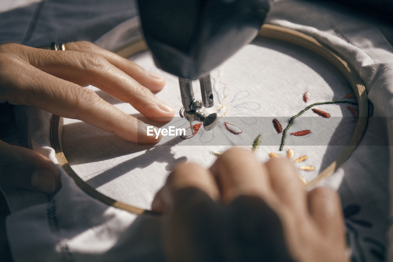 Cropped image of woman embroidering fabric