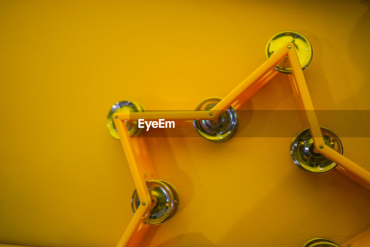 yellow, bicycle, colored background, indoors, no people, studio shot, yellow background, trumpet, brass instrument