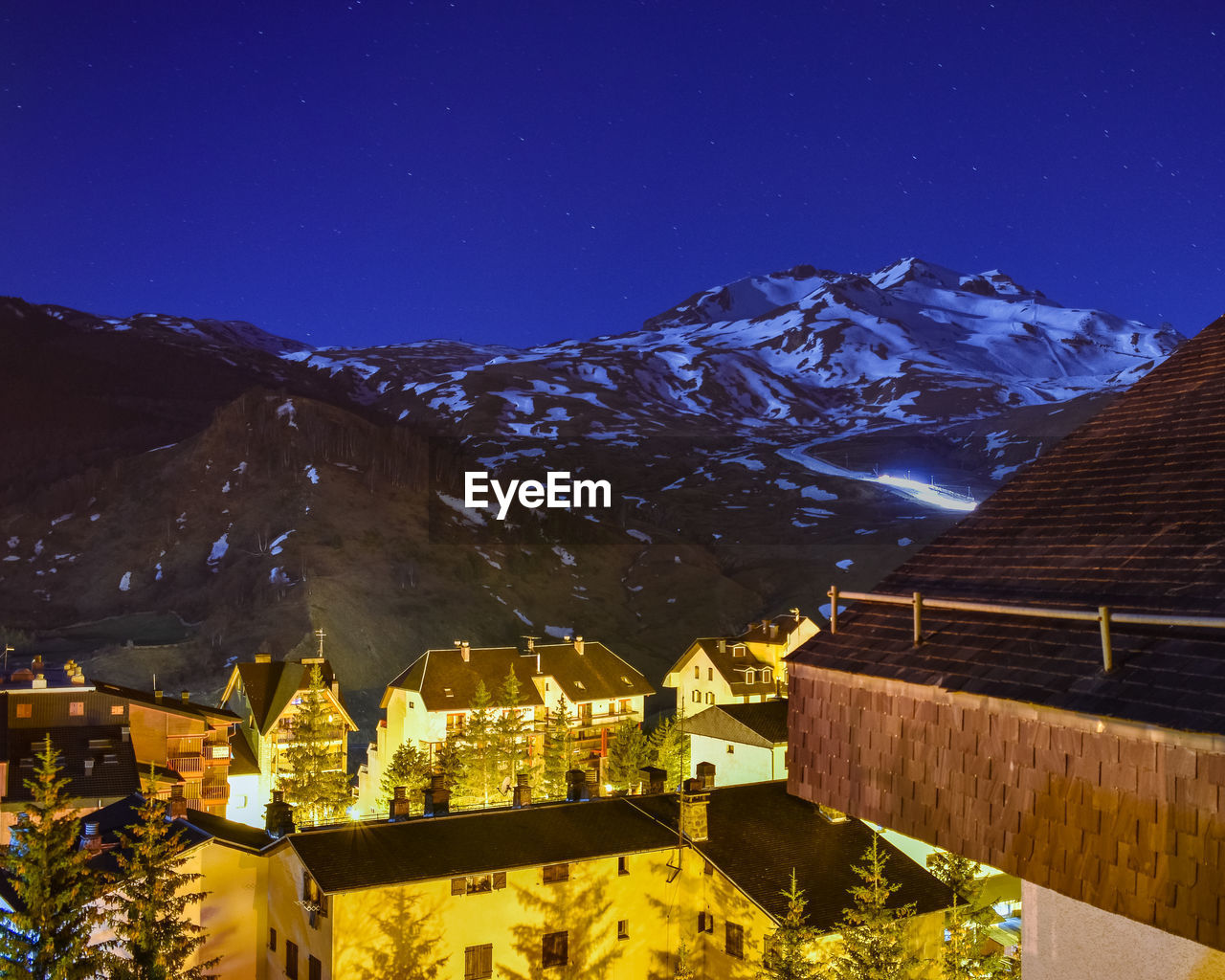 Snow blower working at night in a ski resort in half snowy mountain in pyrenees, spain