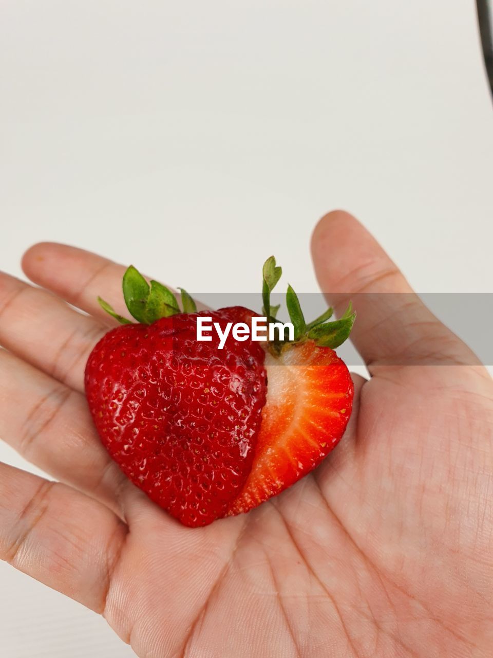 MIDSECTION OF PERSON HOLDING STRAWBERRIES