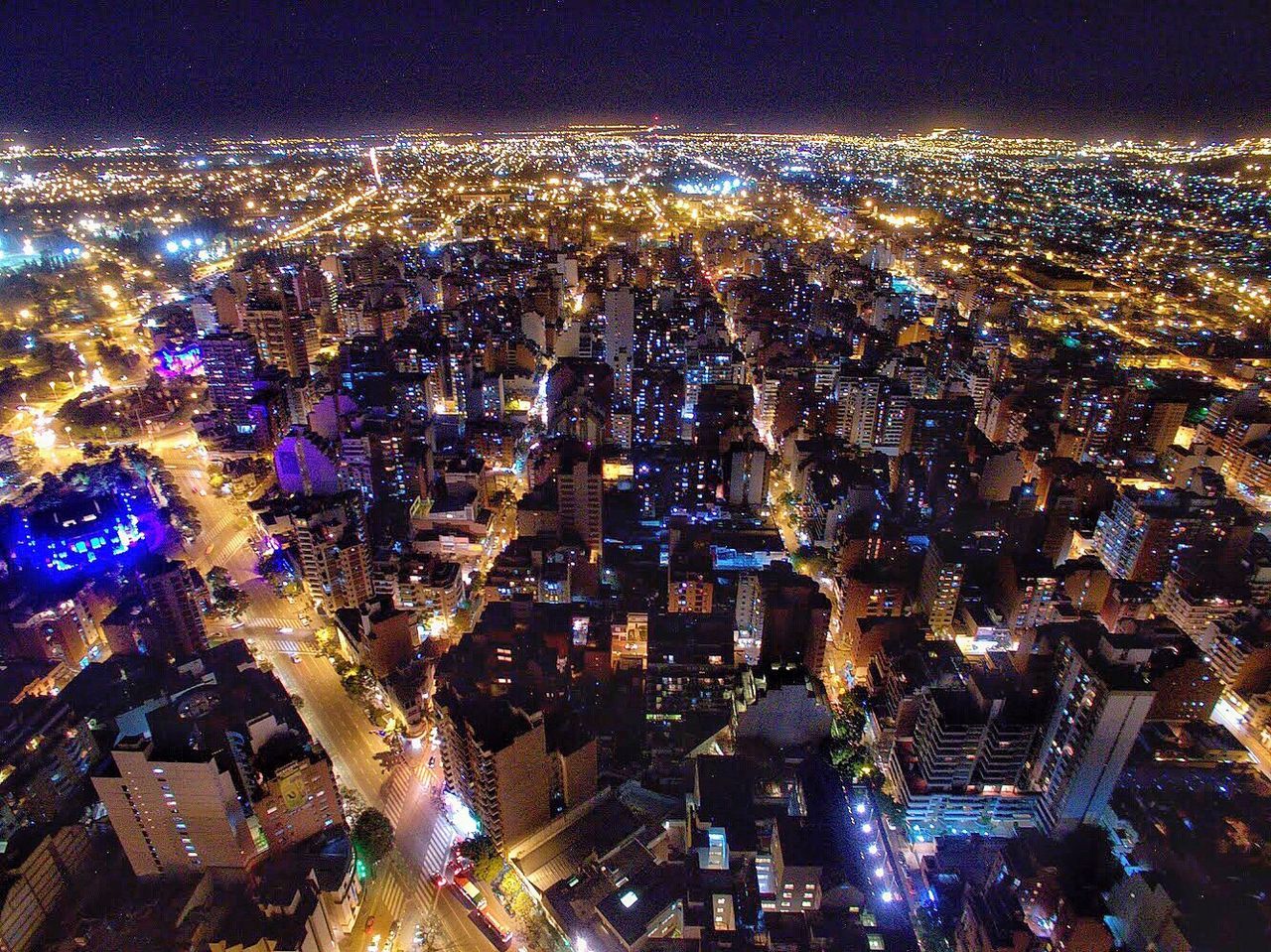 AERIAL VIEW OF ILLUMINATED CITYSCAPE AGAINST SKY