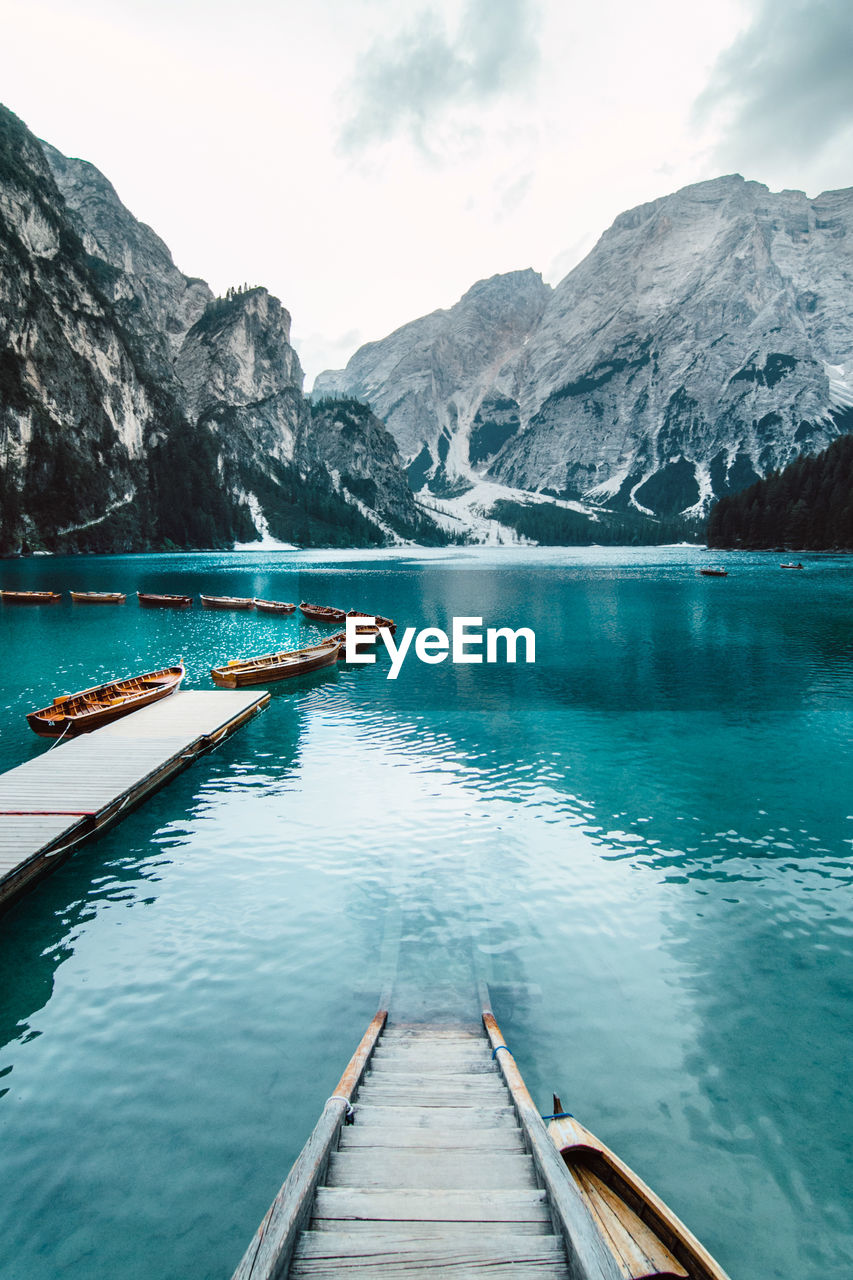 From above wooden quay on amazing scenery of lake with turquoise water in mountains on foggy day