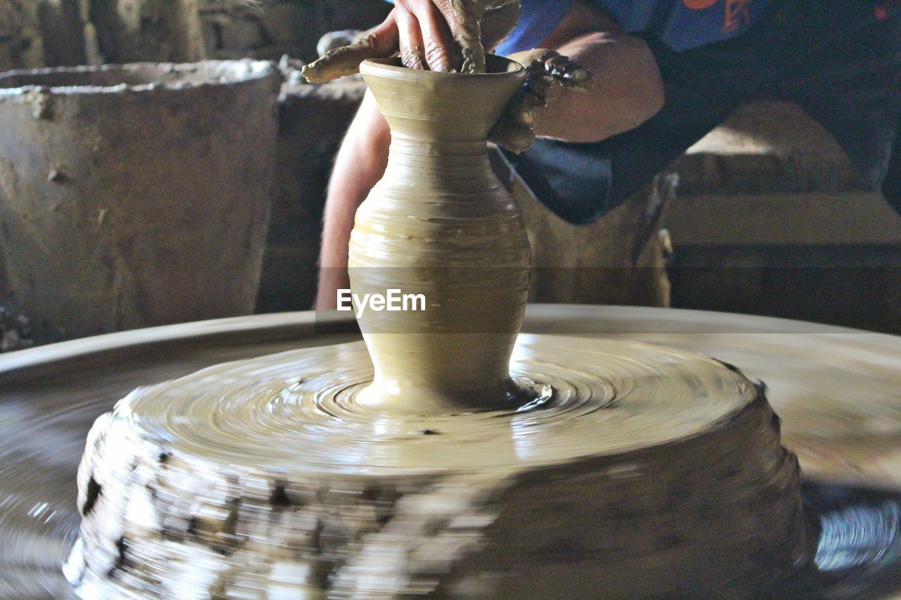 Midsection of man making pottery