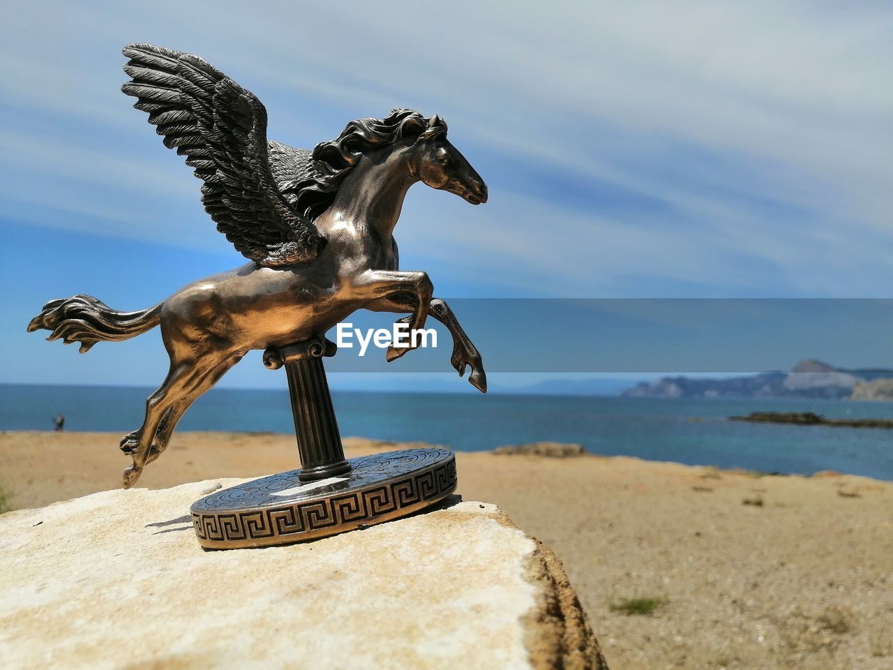 Statue horse on beach against sky