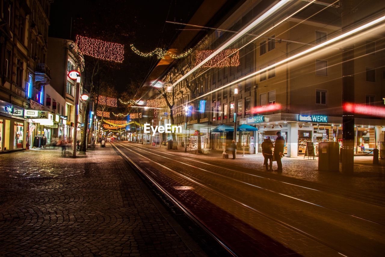 RAILROAD TRACKS IN CITY AT NIGHT