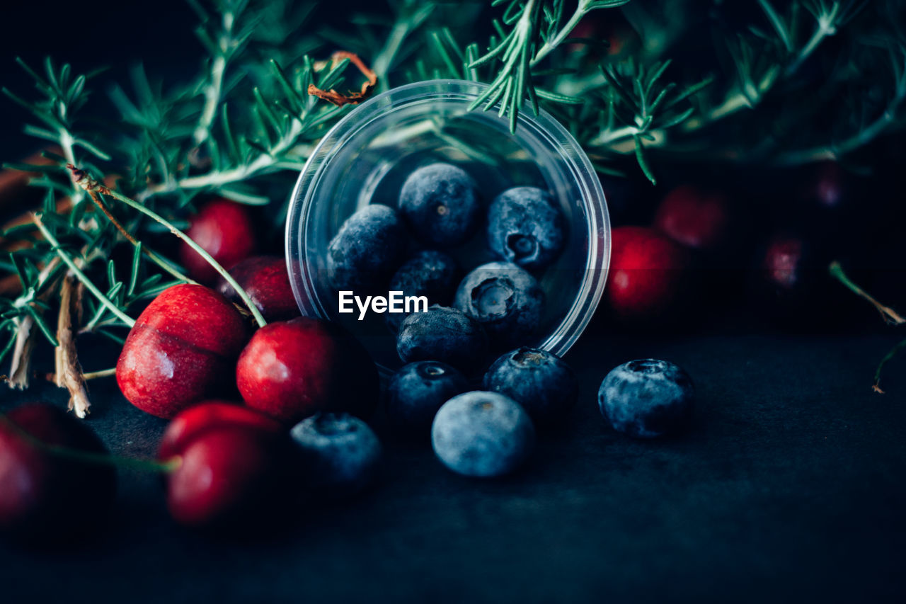 Close-up of fruits with rosemary on table