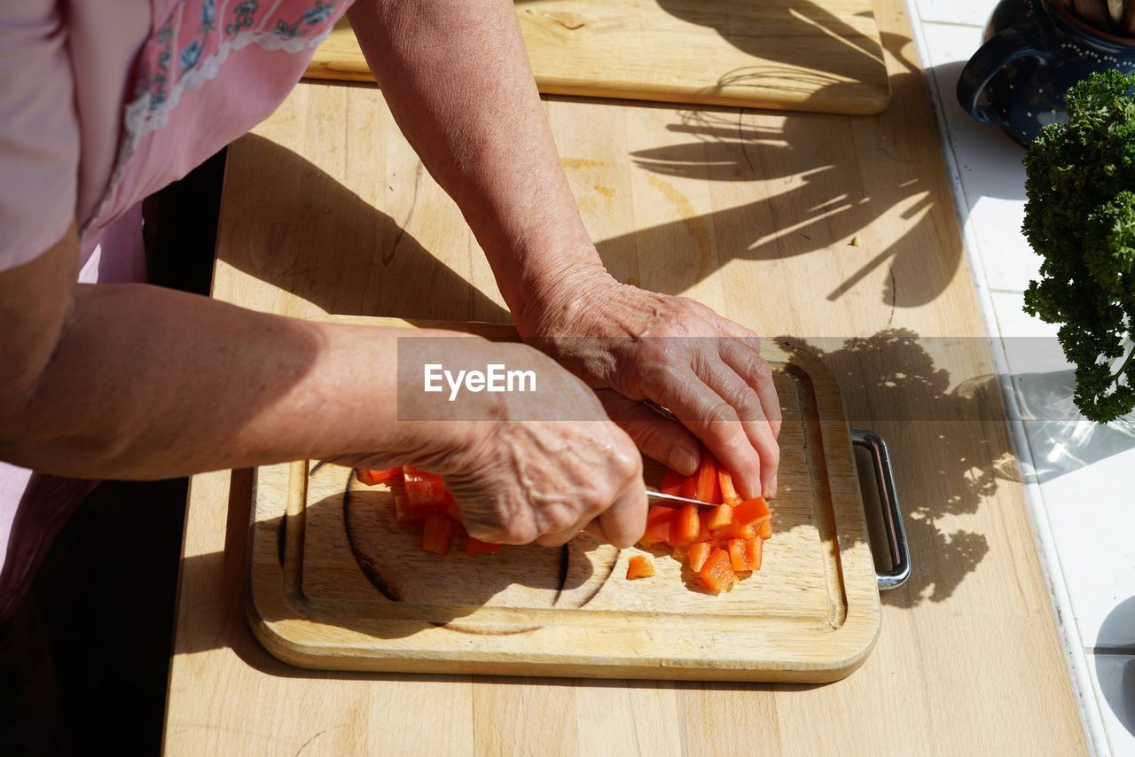 Midsection of man preparing food on cutting board