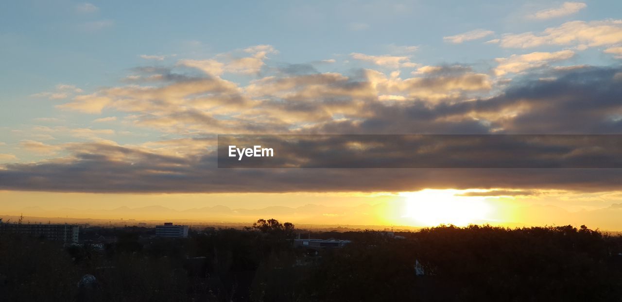 SILHOUETTE BUILDINGS IN CITY AGAINST SKY AT SUNSET