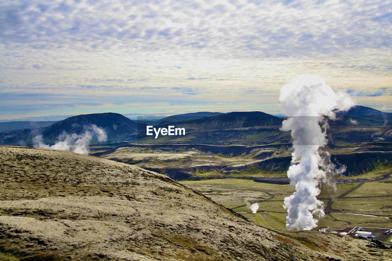 Emission of geothermal energy from icelandic landscape against sky