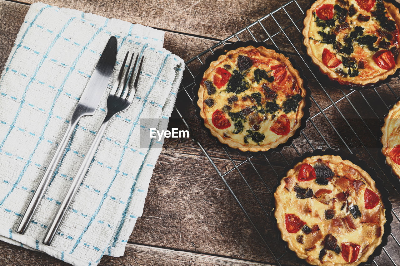 Freshly cooked mini individual quiche pies with filling ingredients ham,onion and spinich 