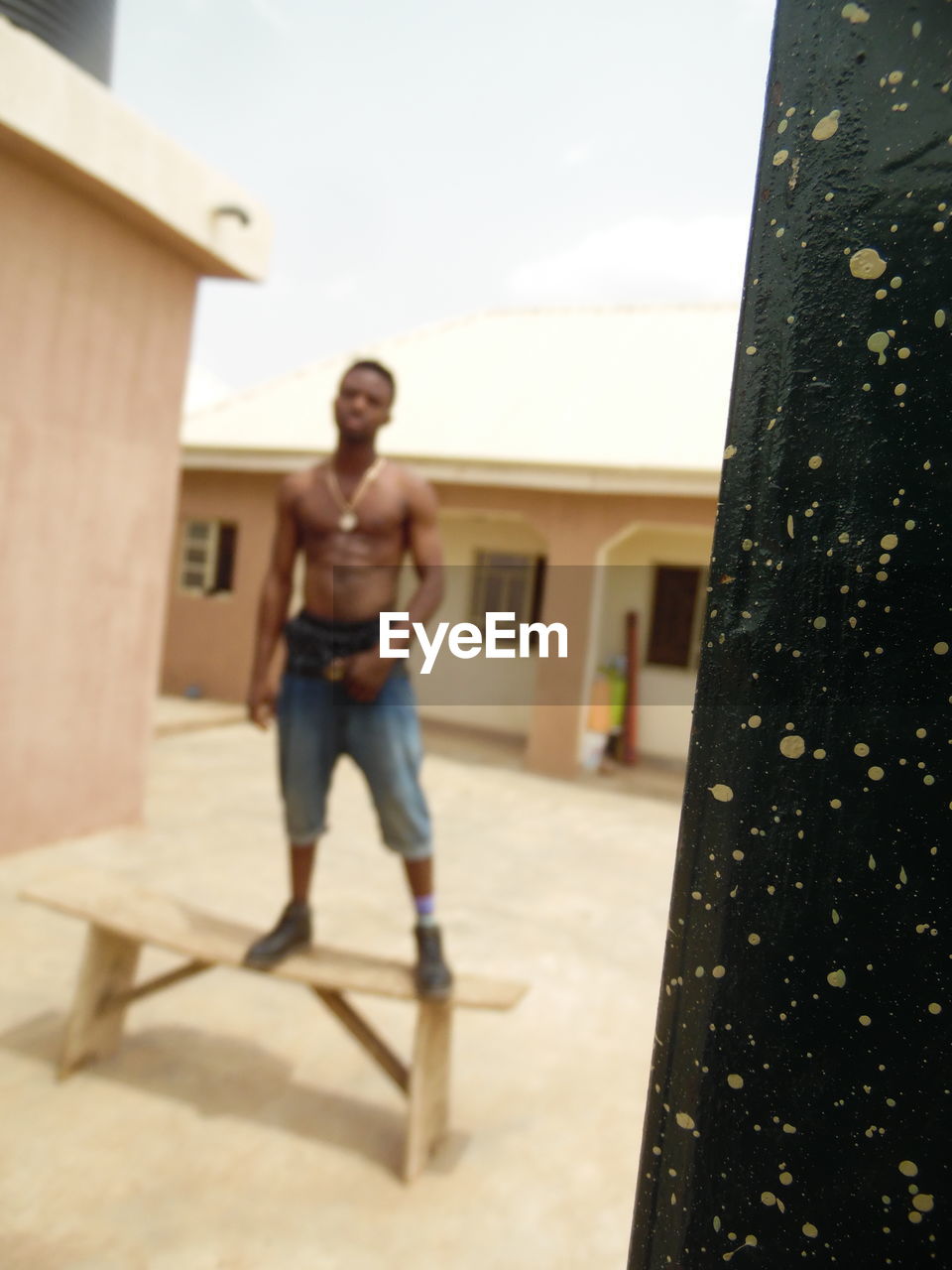 FULL LENGTH OF SHIRTLESS MAN STANDING IN BUILDING