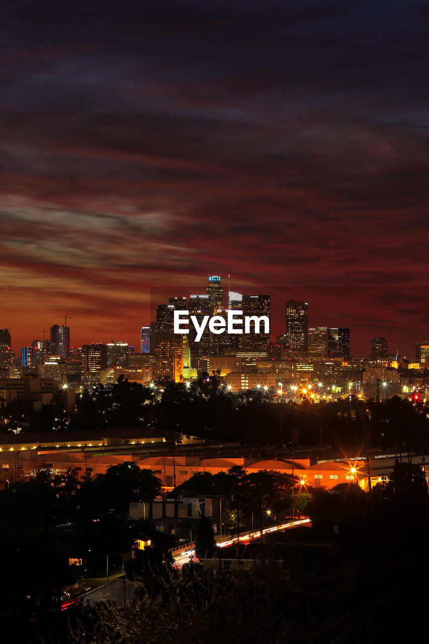 ILLUMINATED CITYSCAPE AGAINST SKY AT NIGHT