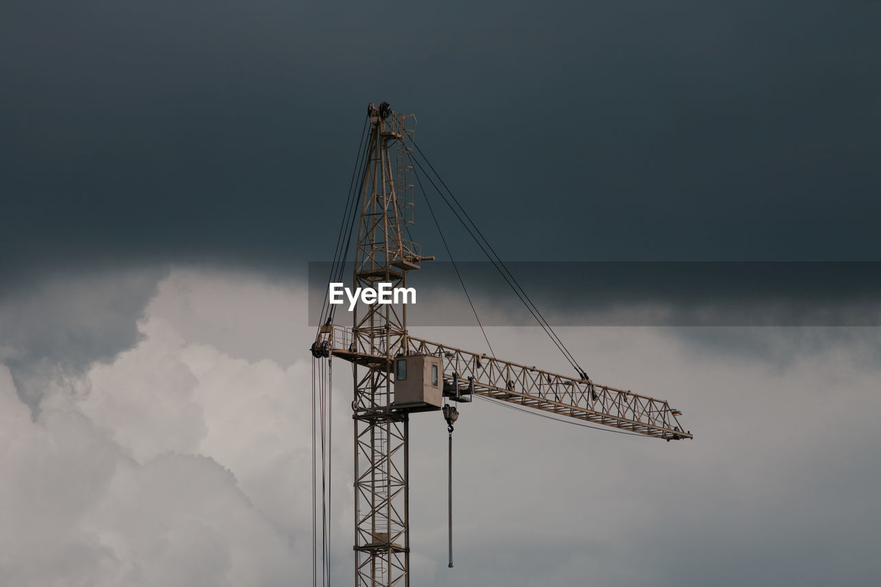 Low angle view of crane against sky