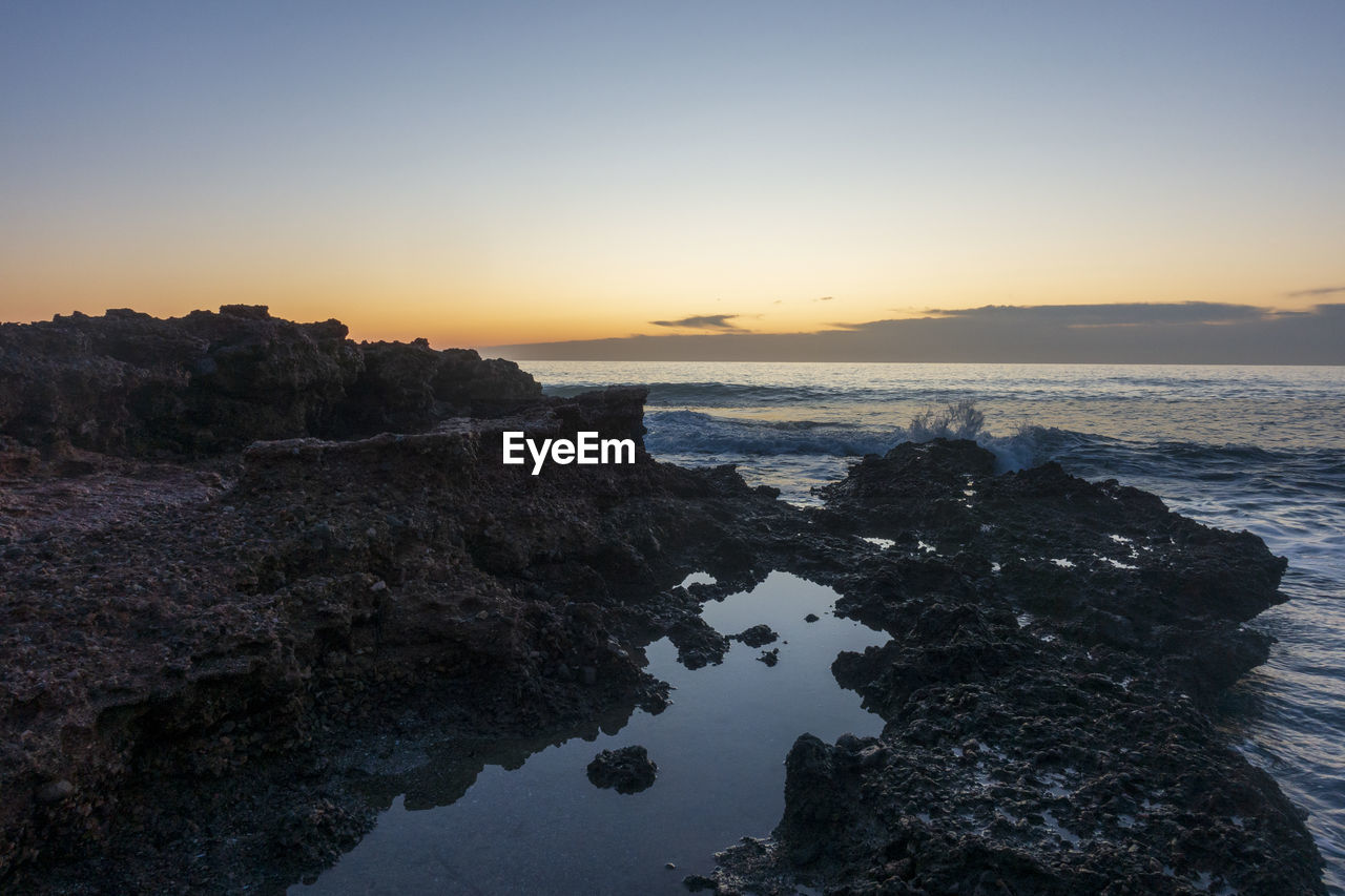 Scenic view of sea against clear sky during sunset