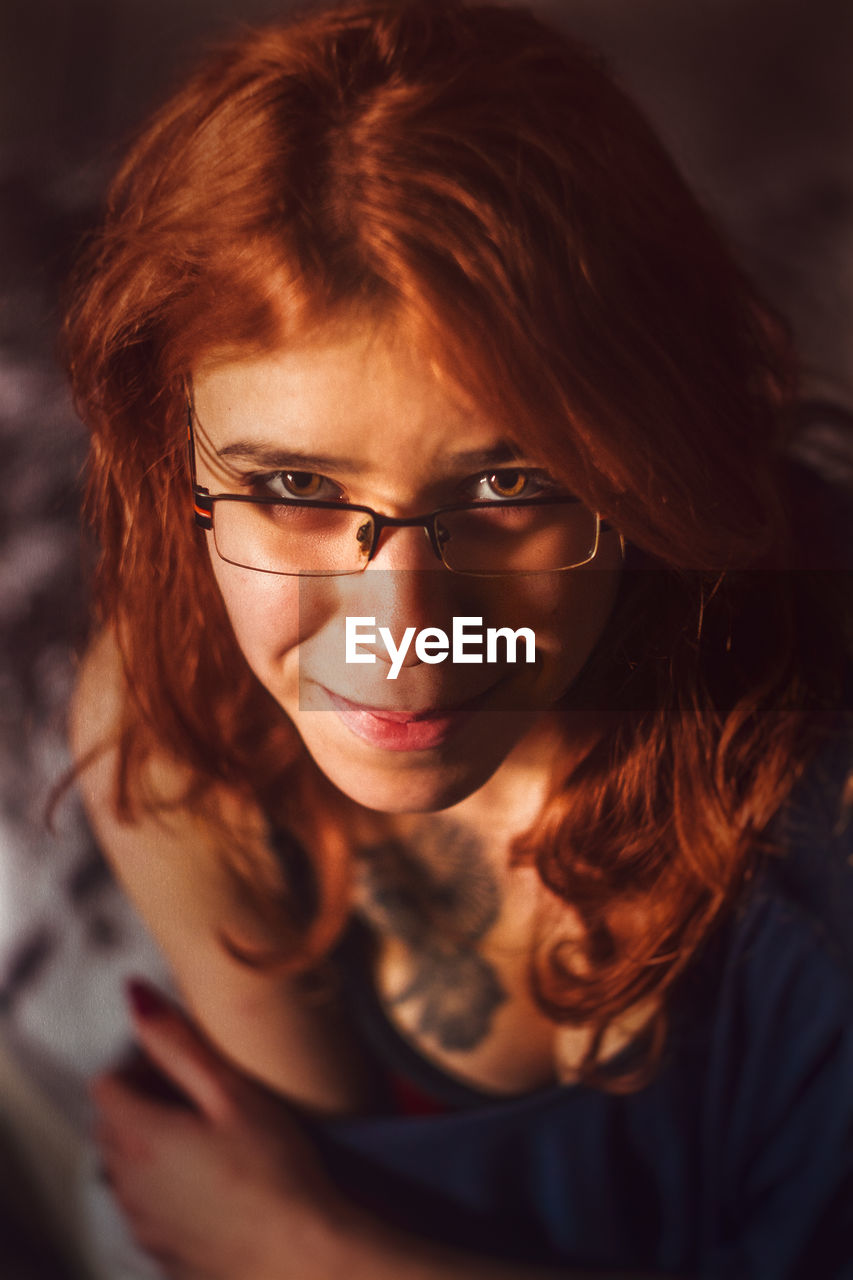 High angle portrait of young redhead woman wearing eyeglasses