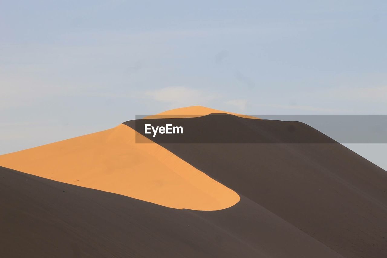 Low angle view of sand against sky on sunny day