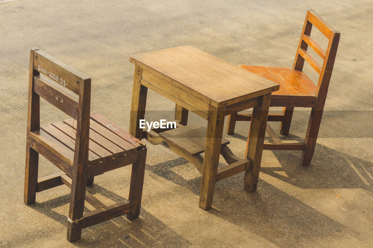 EMPTY CHAIRS AND TABLE ON BEACH