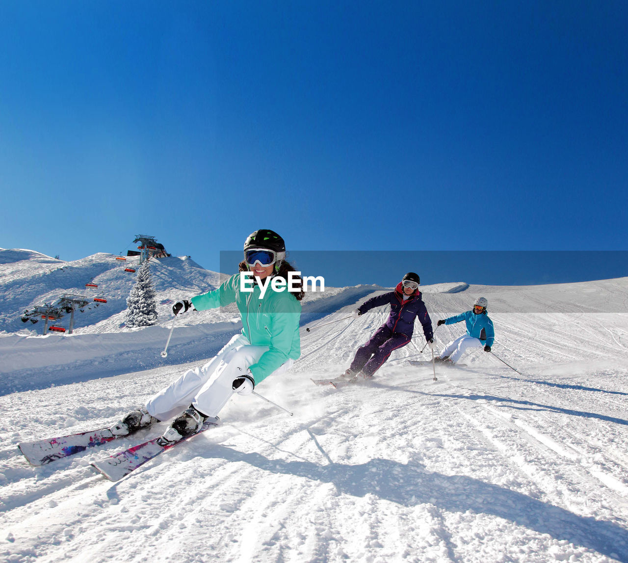PEOPLE SKIING ON MOUNTAIN AGAINST CLEAR BLUE SKY