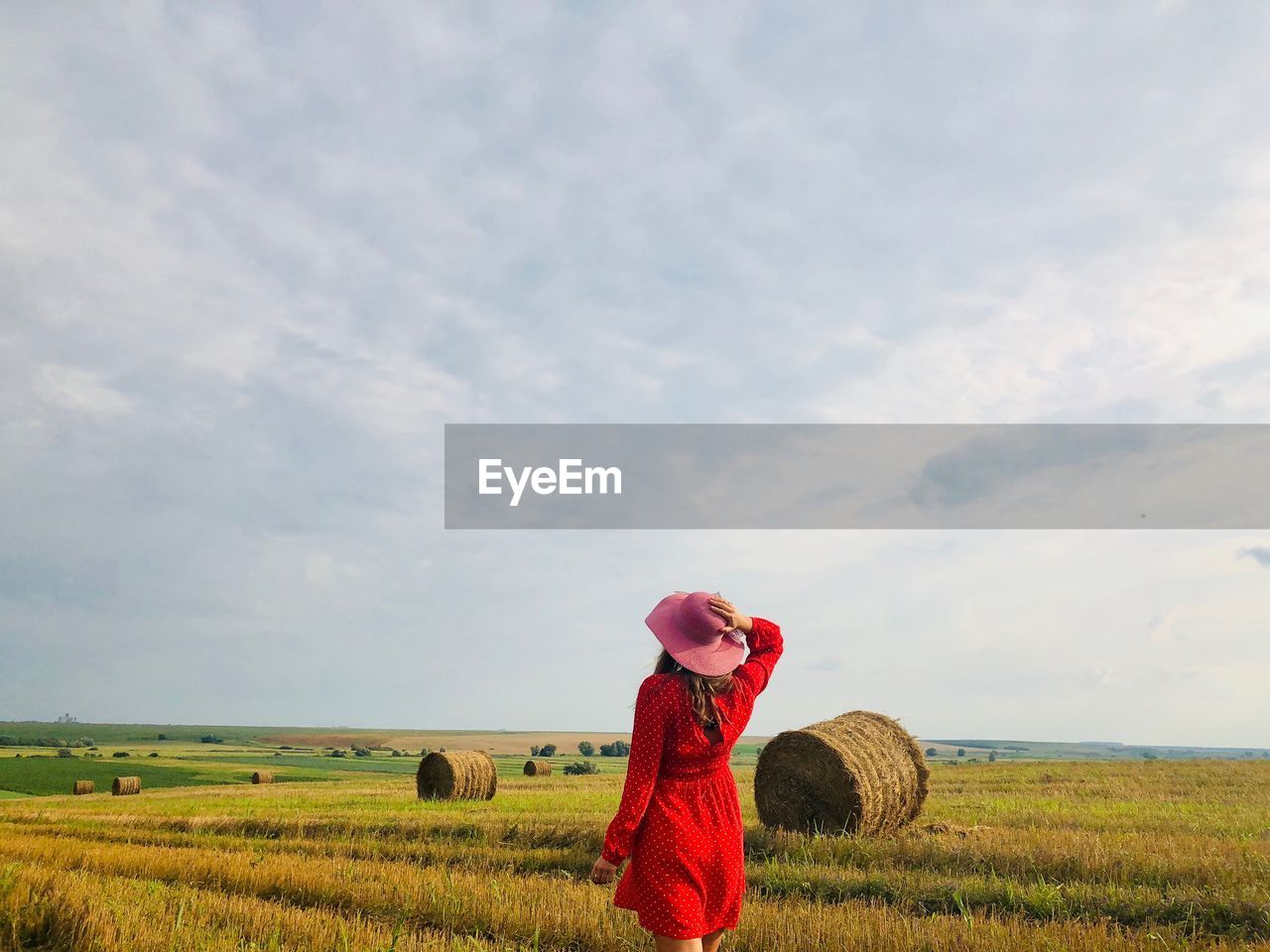 Rear view of woman on field against sky