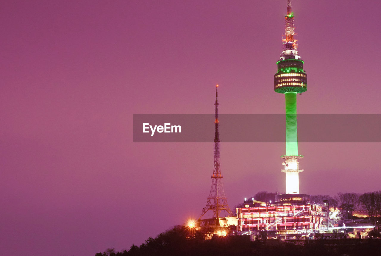 Low angle view of illuminated tower against pink sky