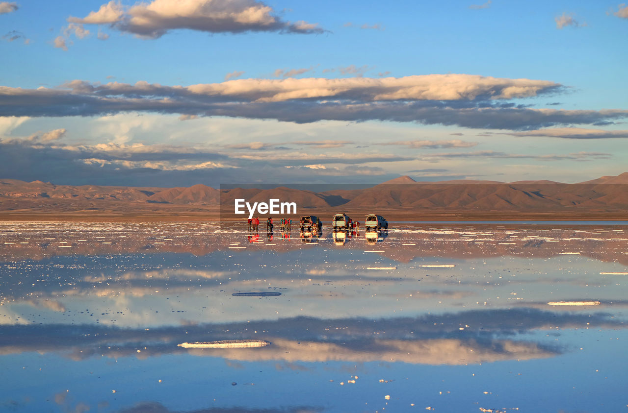 People enjoy the activities on the mirror effect of salar de uyuni salt flats, bolivia