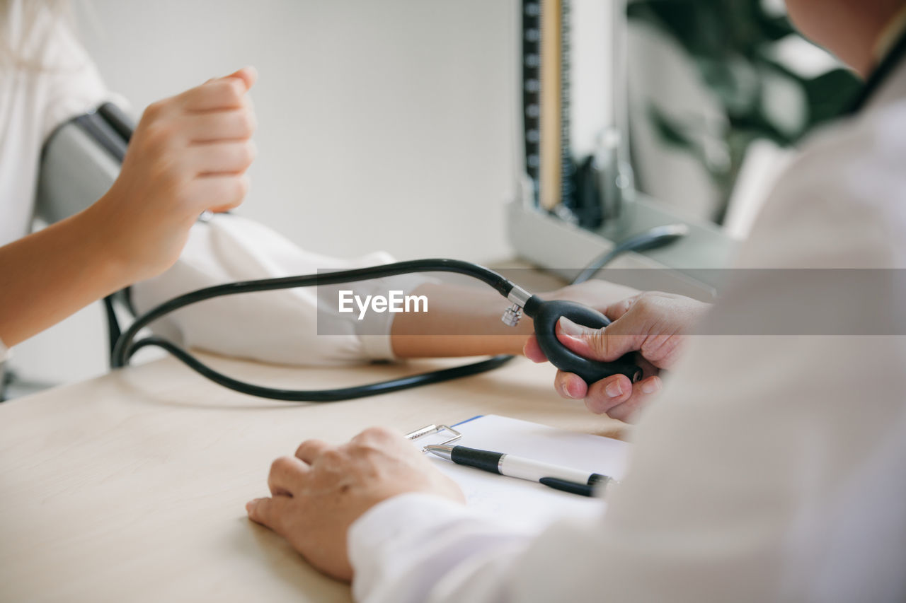 Midsection of doctor examining patient in hospital