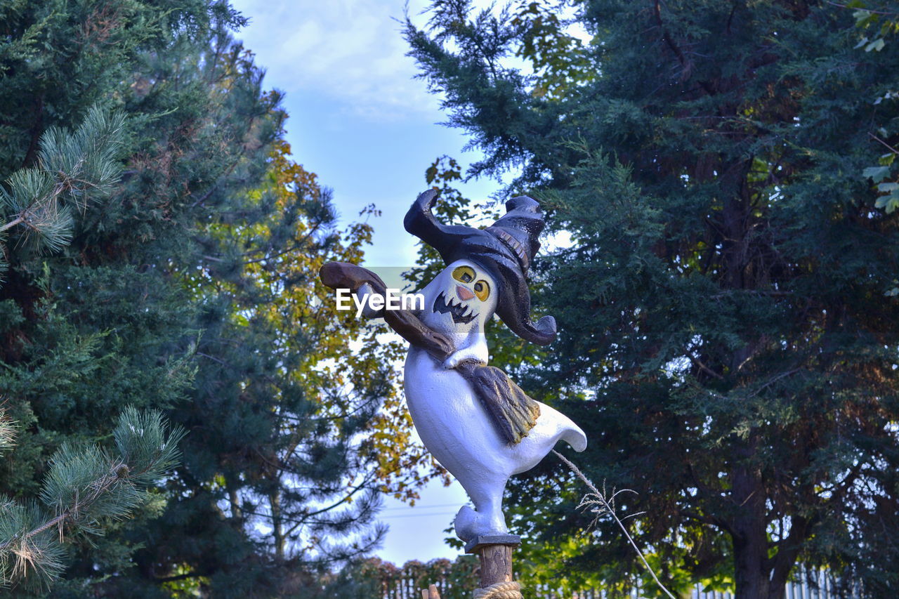 LOW ANGLE VIEW OF STATUE AGAINST TREES AND PLANTS