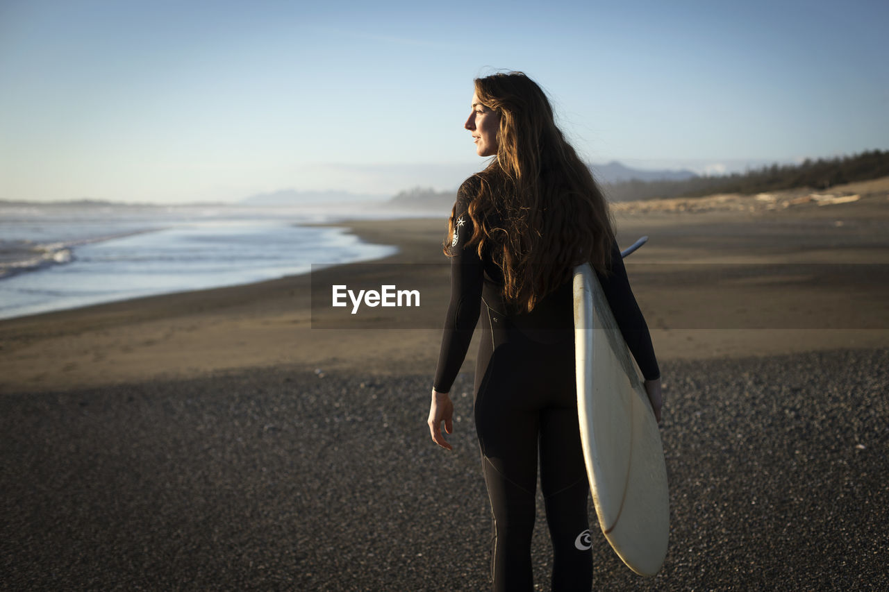 Surfer girl on the beach near tofino