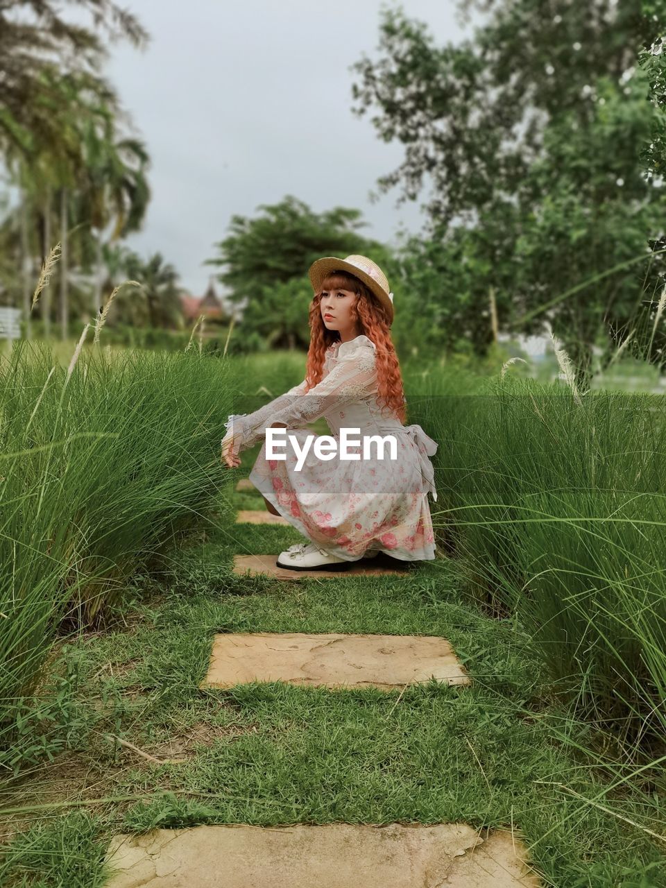 Woman sitting on tree in field