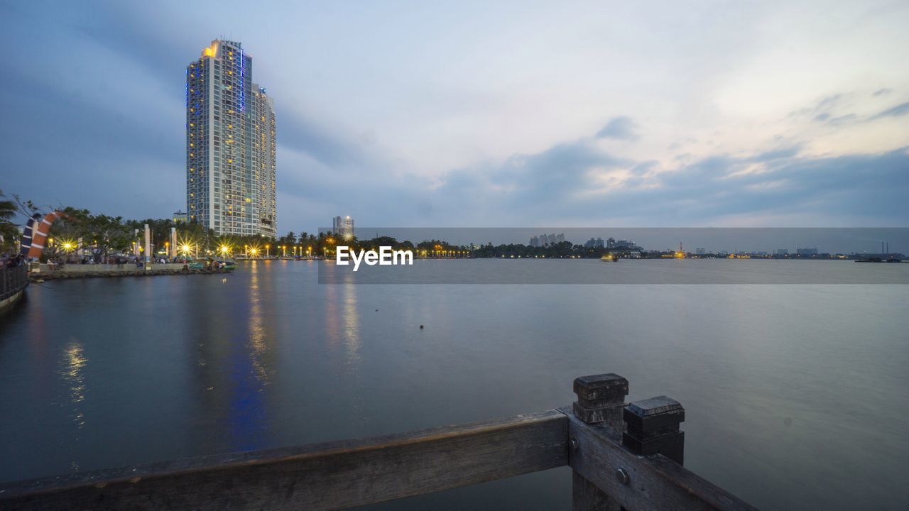 RIVER AND ILLUMINATED BUILDINGS AGAINST SKY