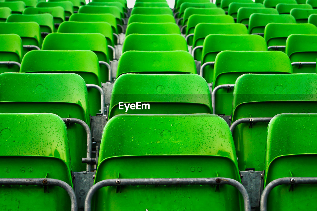 green, in a row, seat, empty, chair, repetition, stadium, no people, absence, full frame, side by side, large group of objects, arts culture and entertainment, abundance, order, backgrounds, bleachers, sport venue, arrangement, auditorium, sports