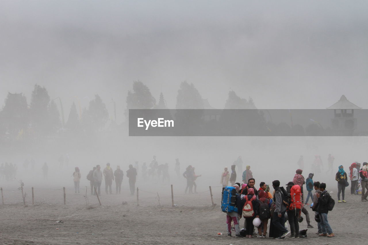 People walking on land against sky