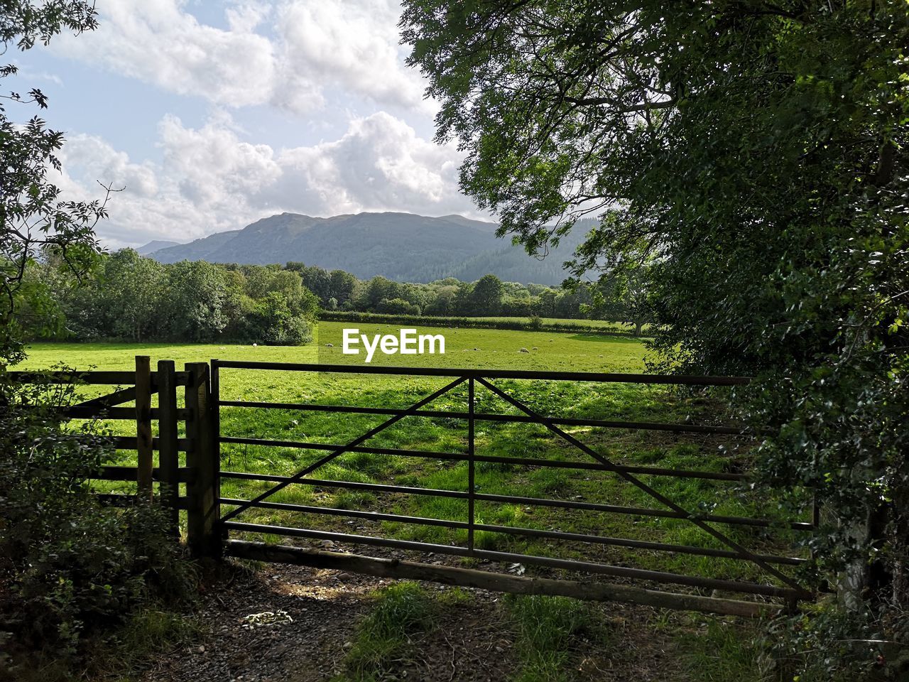 Scenic view of field against sky with farm gate