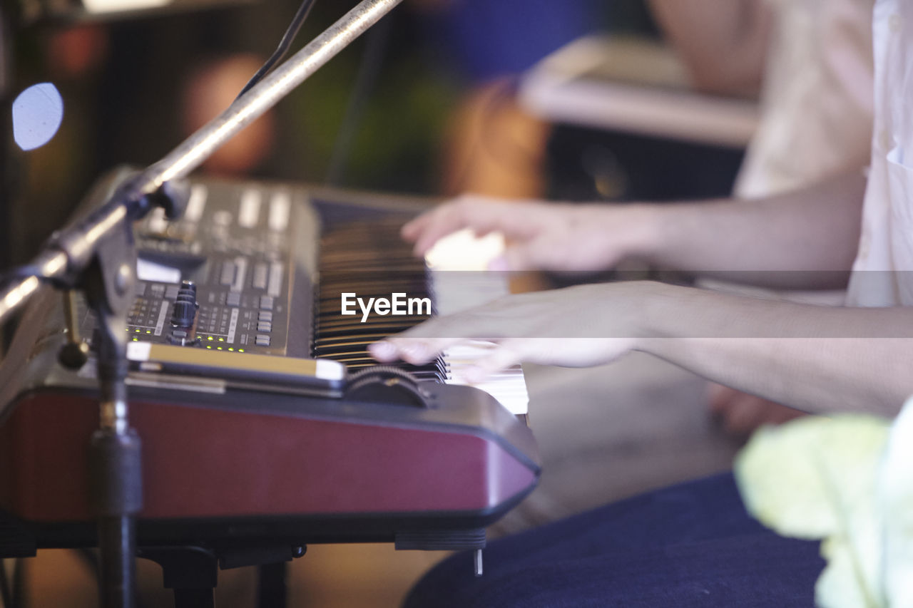 Cropped hands of person playing piano