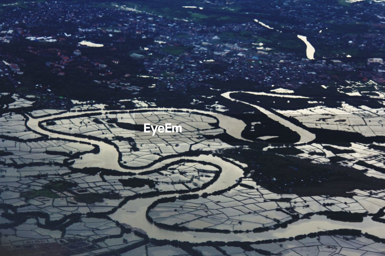 Aerial view of river by city at dusk