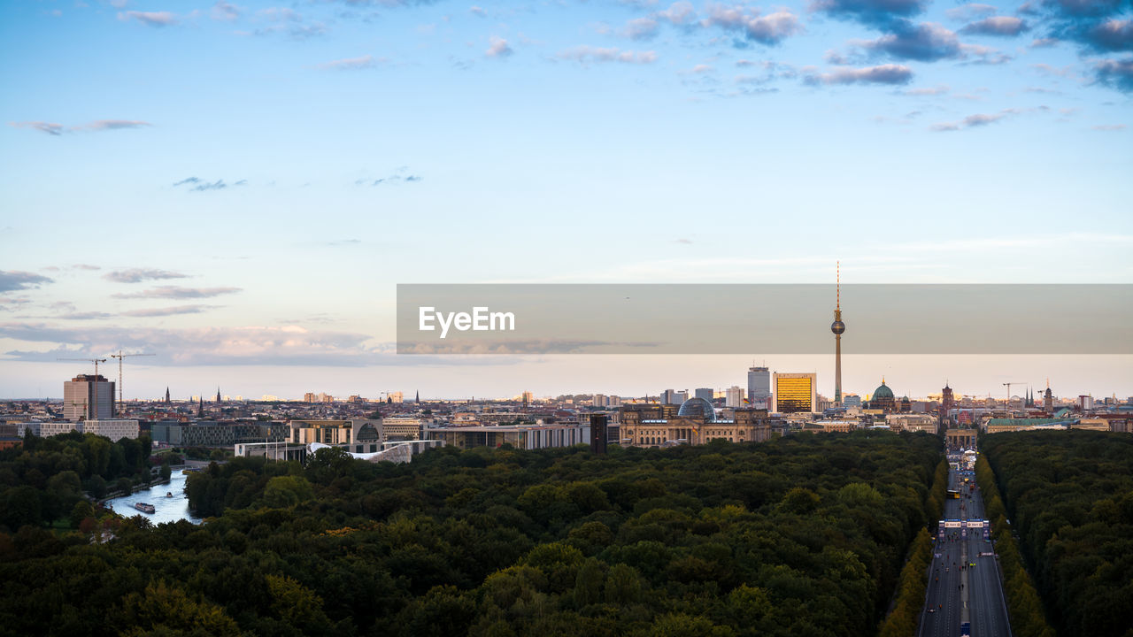 Fernsehturm and cityscape by tiergarten against sky