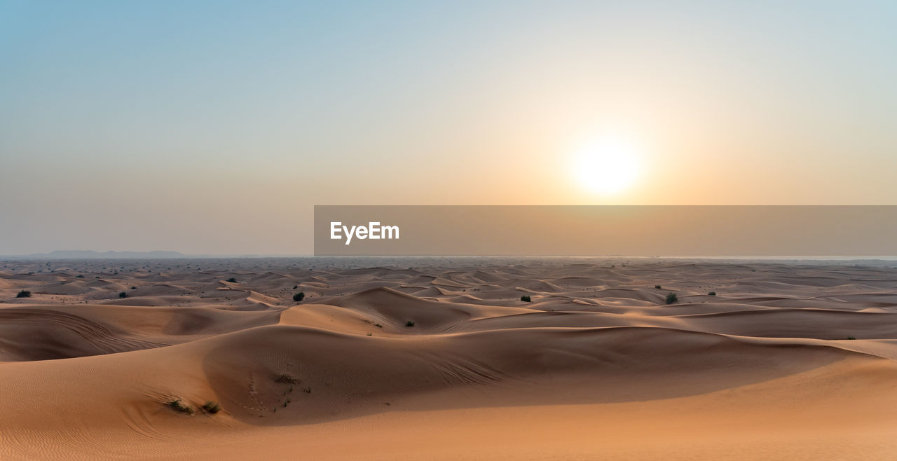 Scenic view of desert against sky during sunset