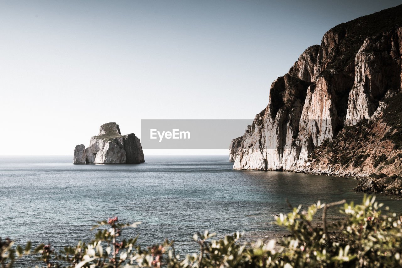 Scenic view of so called pan di zucchero rocks formation in sea against clear sky