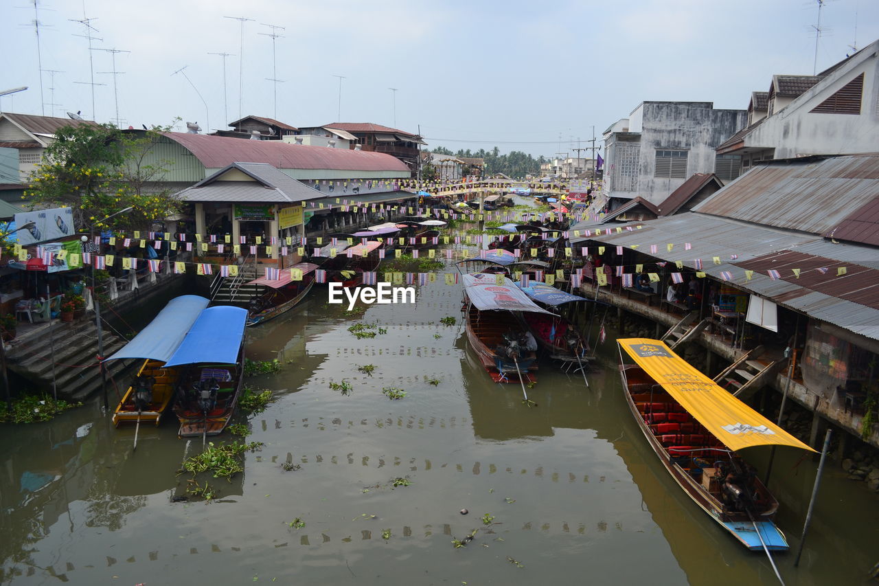 Boats in canal amidst buildings in city