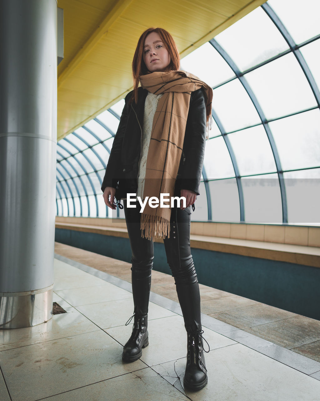 Portrait of young woman standing on footbridge