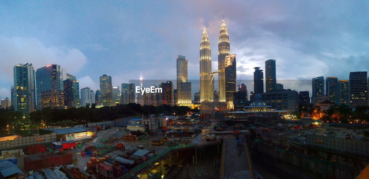 Scenic view of cityscape against cloudy sky