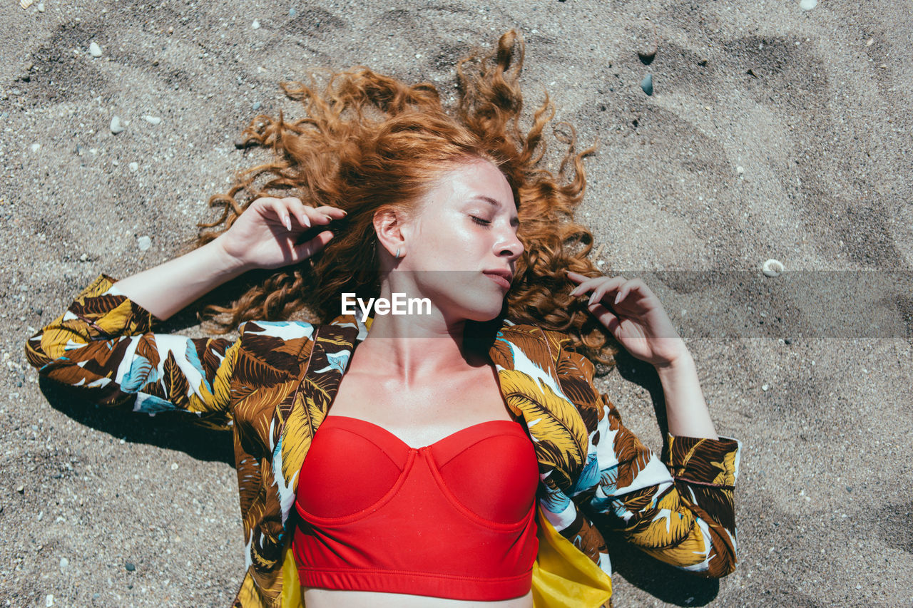 HIGH ANGLE VIEW OF YOUNG WOMAN LOOKING AT CAMERA