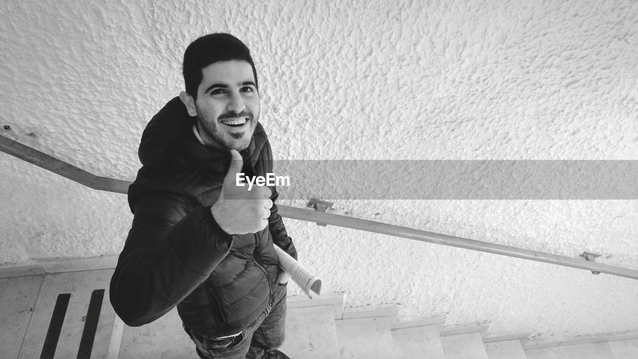 Portrait of smiling young man showing thumbs up