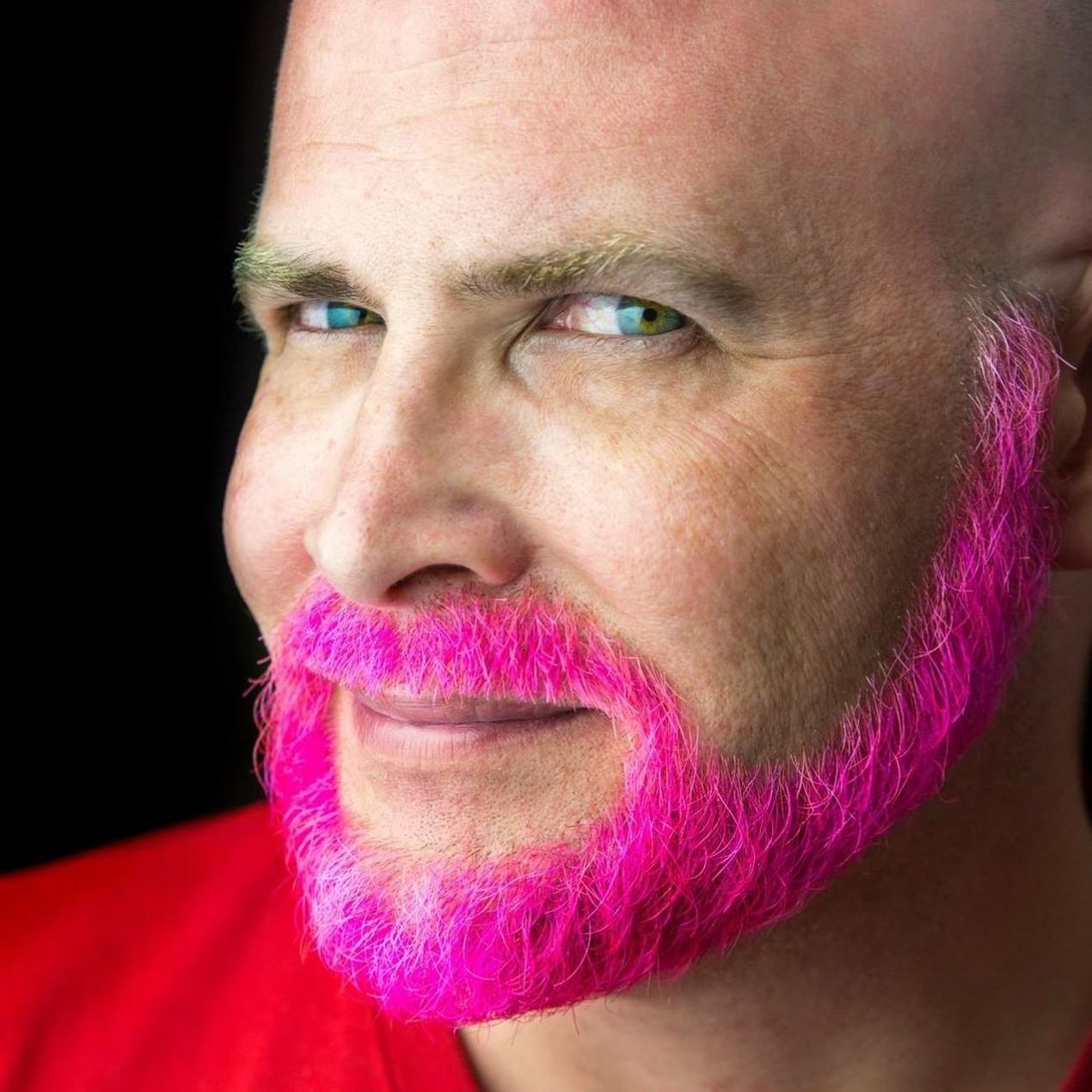 Headshot of man with pink beard