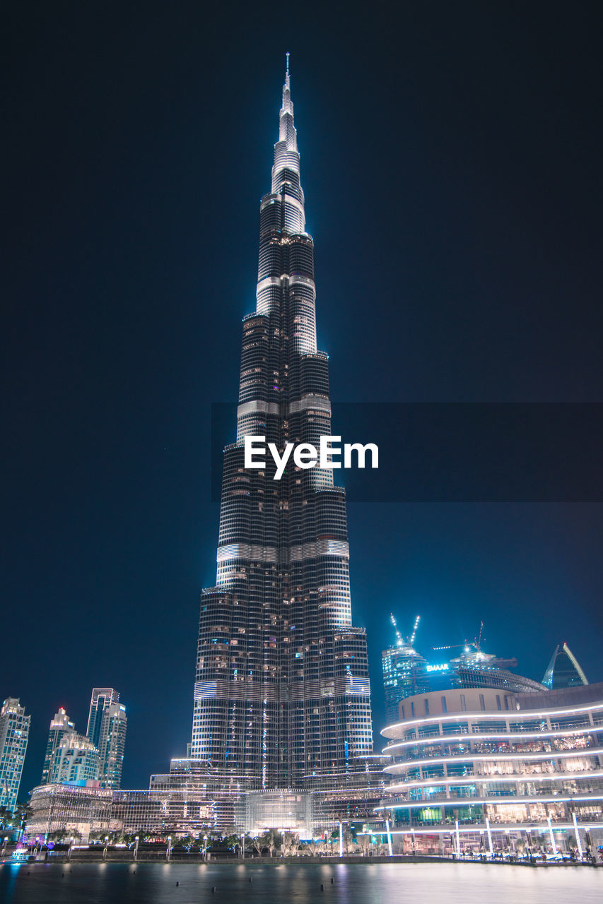 LOW ANGLE VIEW OF ILLUMINATED BUILDINGS AGAINST CLEAR SKY