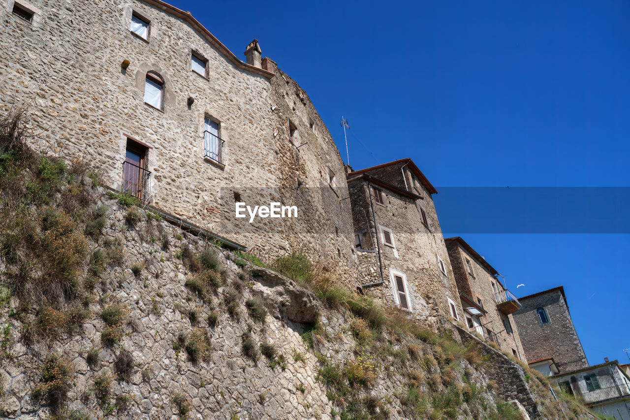 low angle view of old ruins against blue sky