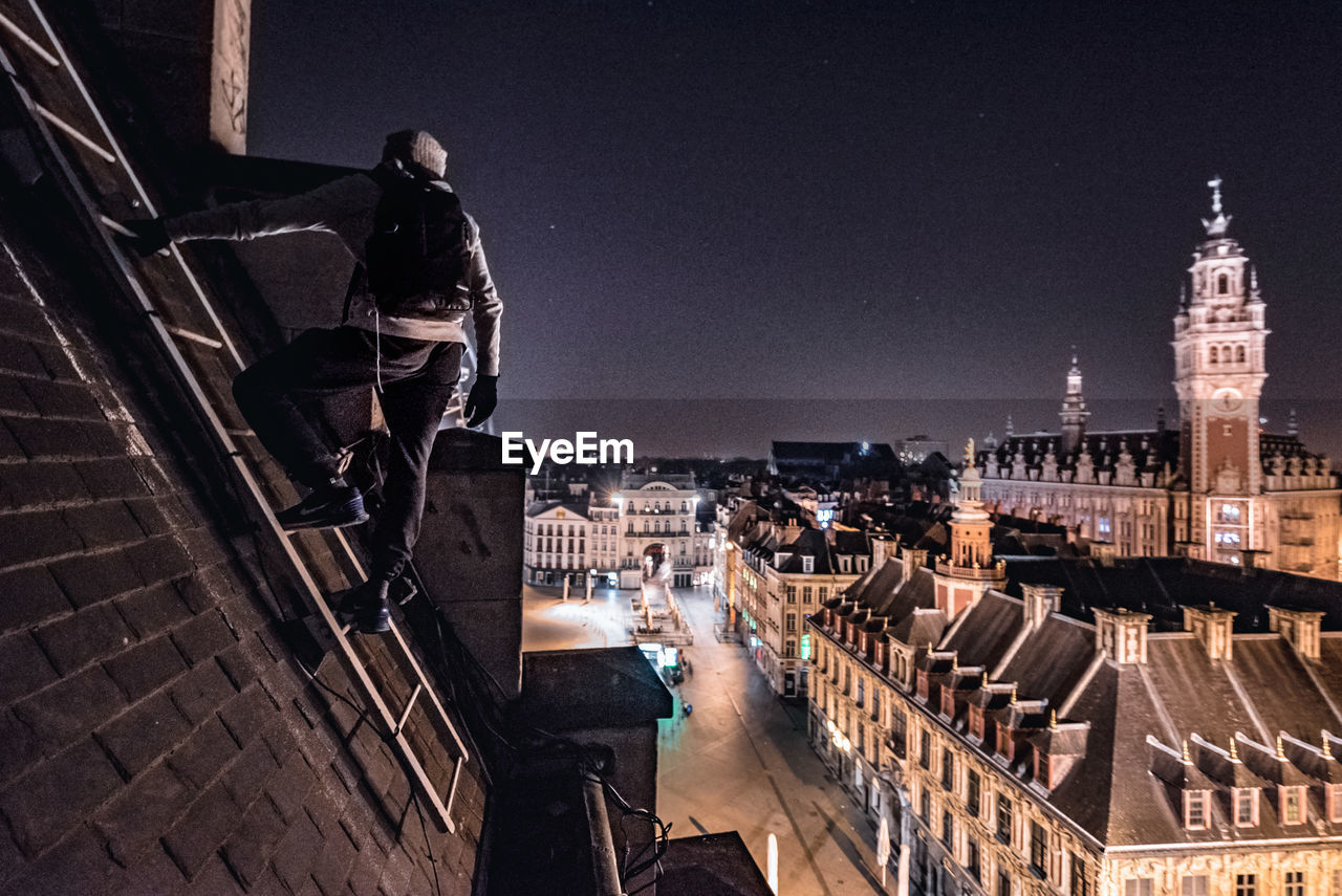 Man climbing rooftop