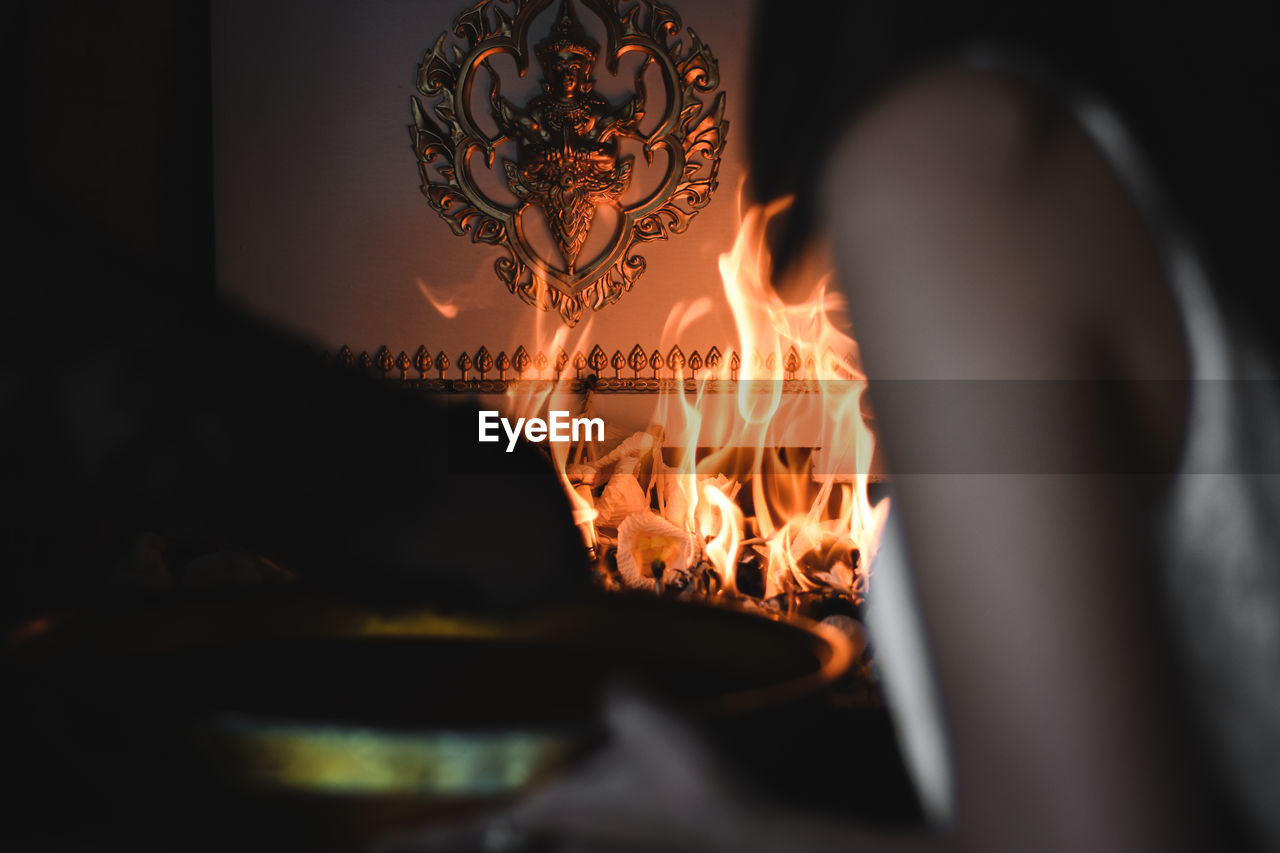 CLOSE-UP OF LIT CANDLES ON WOODEN TABLE